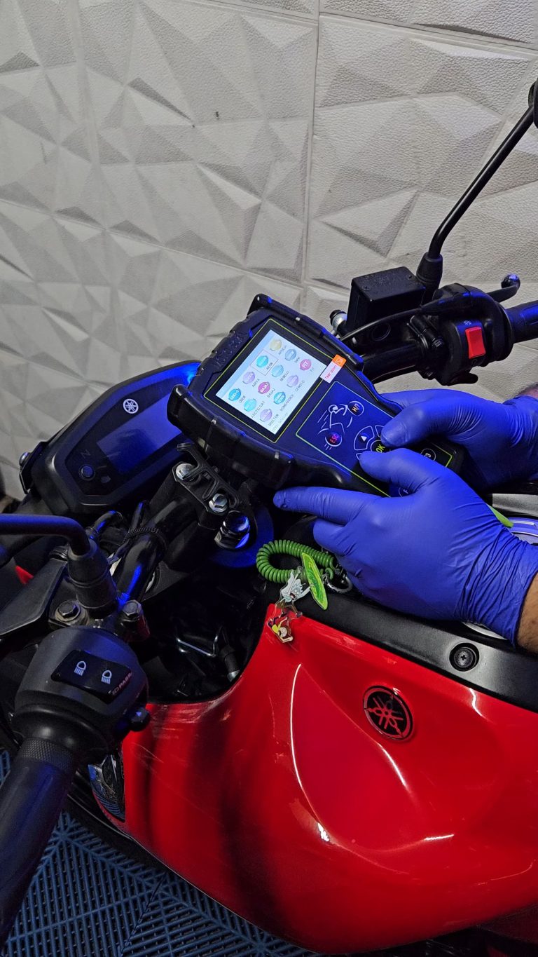 Mecanico realizando escaneo en moto yamaha en taller personalizado para motocicletas Yamaha